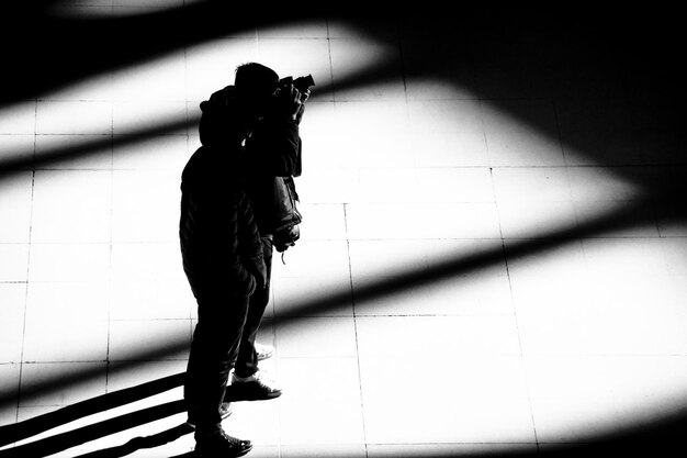 Photo silhouette man photographing against wall