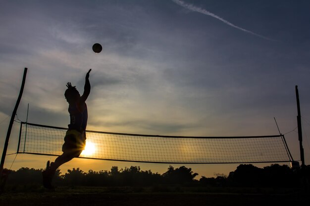 Foto uomo a silhouette che gioca a pallavolo contro il cielo durante il tramonto