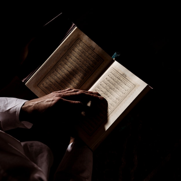 Silhouette of man reading in quran