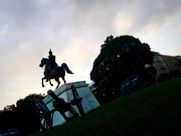 Photo silhouette man riding horse statue against sky