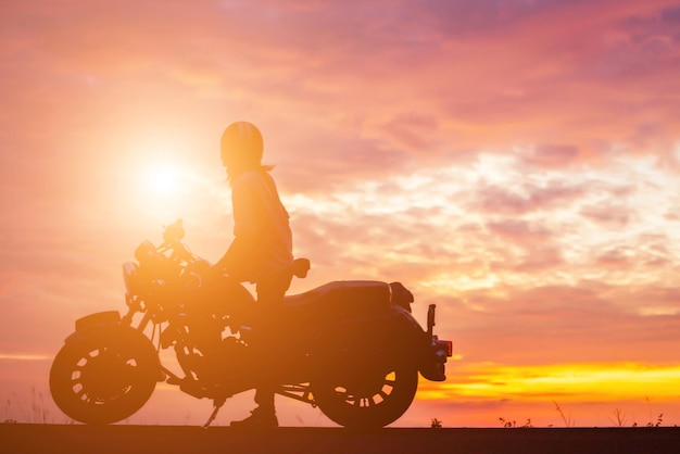 Photo silhouette man riding motorcycle against orange sky