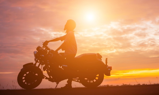 Silhouette man riding motorcycle against sky during sunset