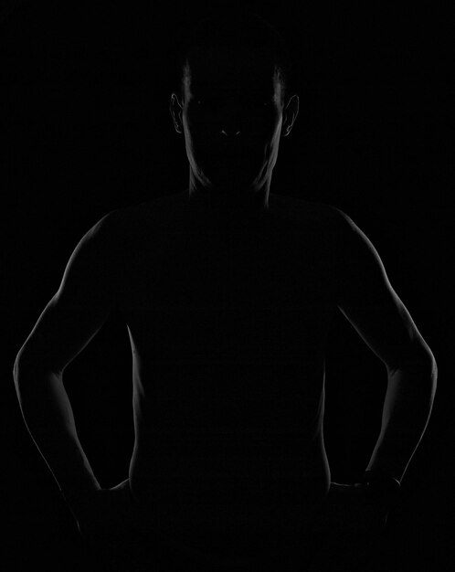 Silhouette man standing against black background