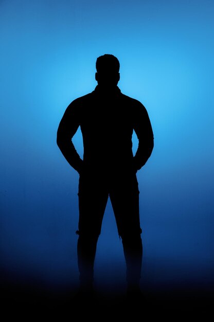 Silhouette man standing against illuminated blue sky