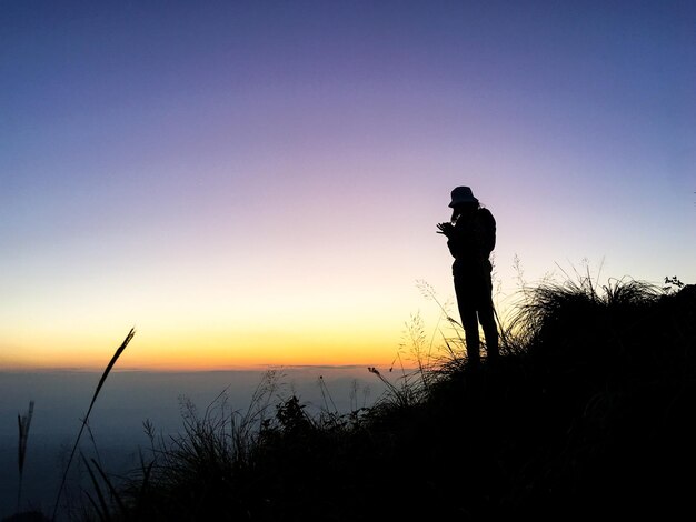 Фото Силуэт человека, стоящего на небе во время захода солнца