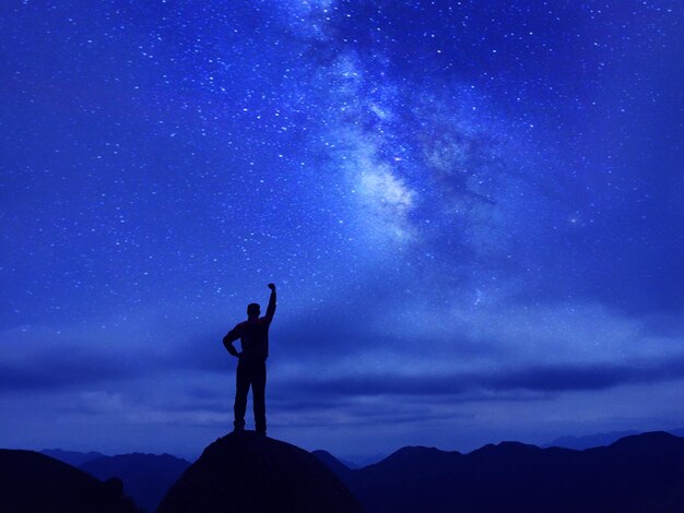 Silhouette man standing against sky at night