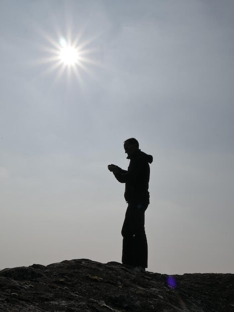 Silhouette of man standing against sky