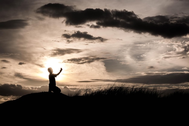 Photo silhouette man standing on field against sky during sunset