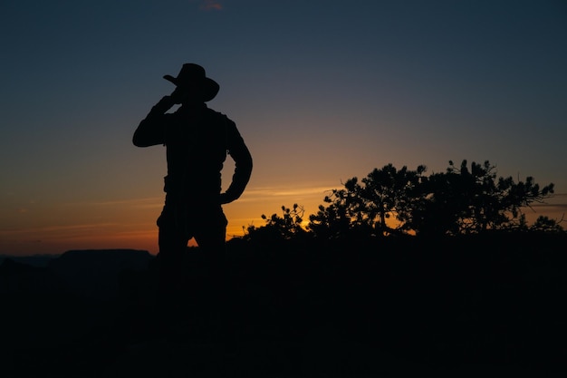 Foto silhouette uomo in piedi sul campo contro il cielo durante il tramonto
