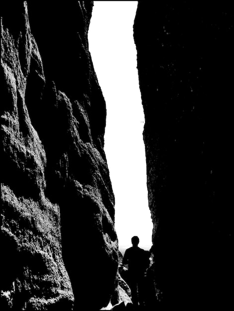 Foto silhouette di un uomo in piedi tra grandi rocce