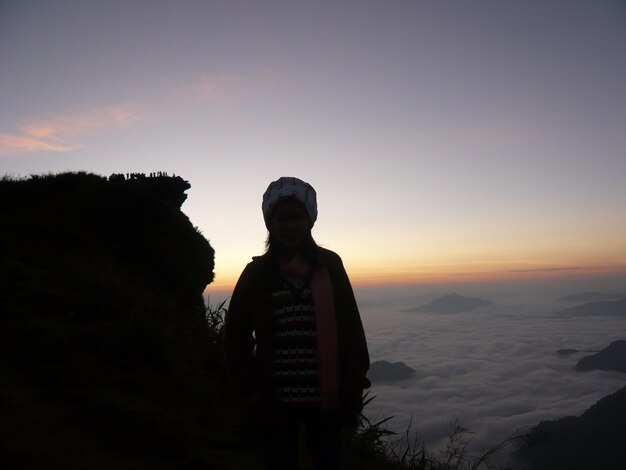 Silhouette man standing on mountain against sky during sunset