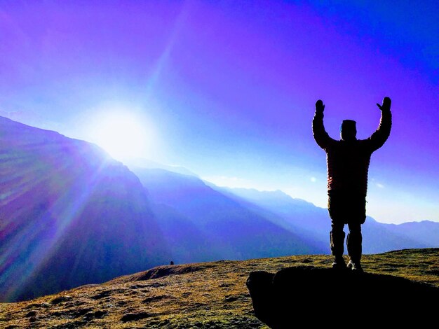 Silhouette man standing on mountain against sky