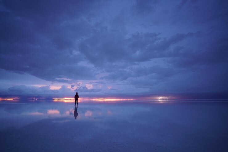 Photo silhouette man standing in salt flats against sky during sunset