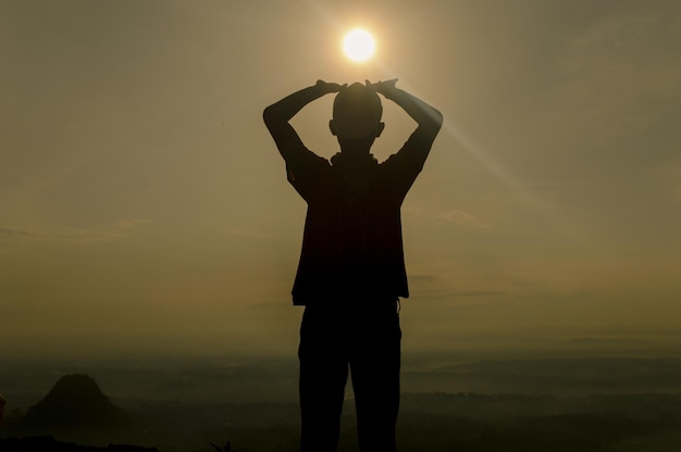 太陽の下に立っている男のシルエット