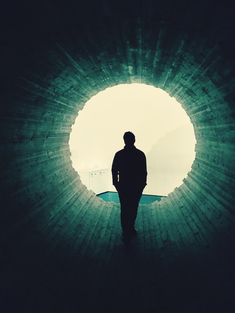 Photo silhouette man standing in tunnel