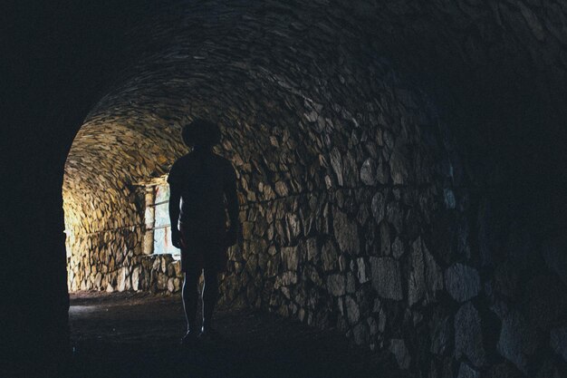 Silhouette of man standing in tunnel