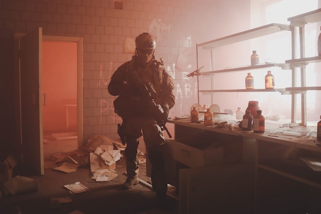 силуэт человека в форме с оружием в старой комнате в красном дыме