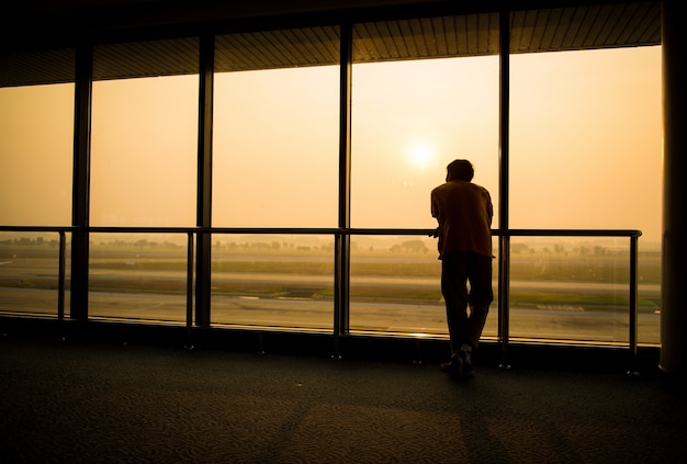 Photo silhouette of man waiting for the flight