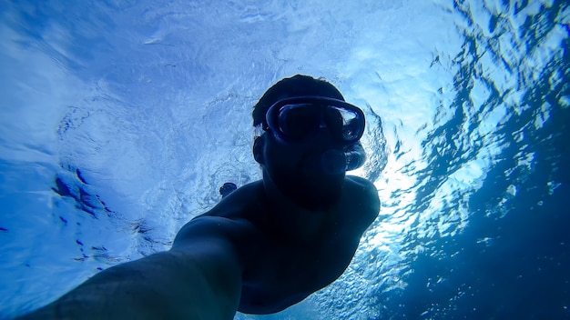 The silhouette of a man who dived to the bottom of the red sea