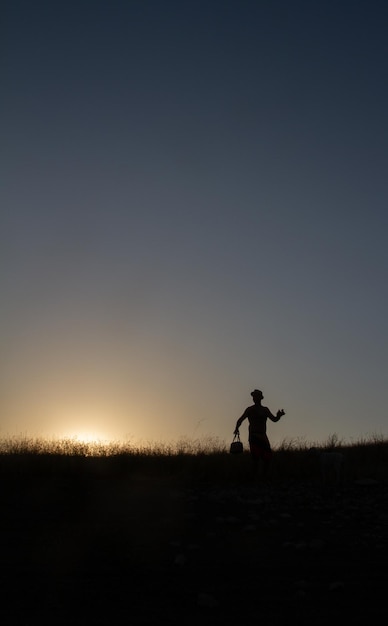 Photo silhouette of a man with a hat at sunset