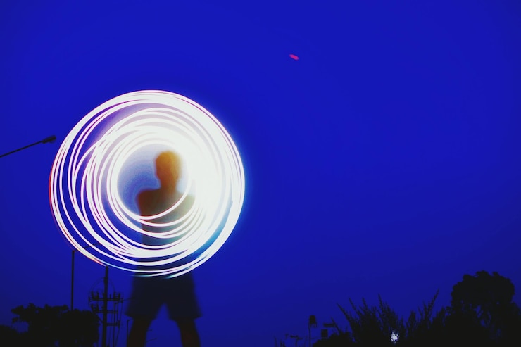 Photo silhouette man with light painting against blue sky