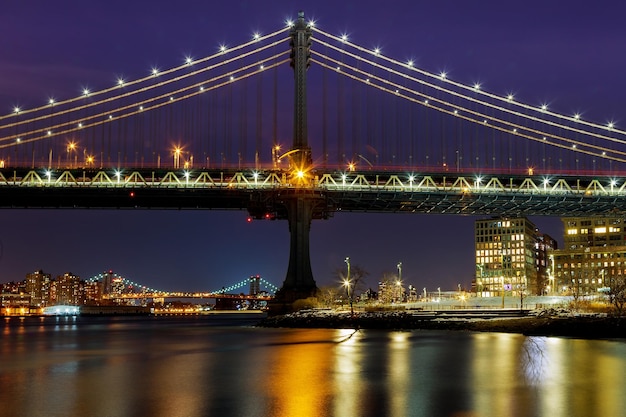 Силуэт Манхэттенского моста Манхэттен на фоне линии горизонта ночью