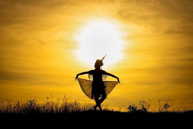 Silhouette Manohra women dance with sunset in South of Thailand.