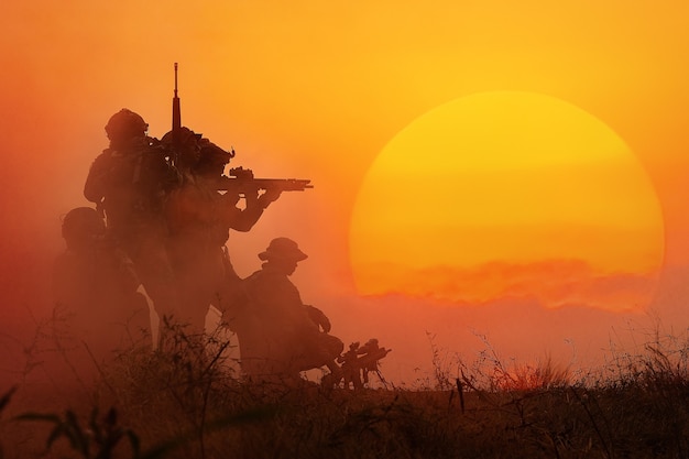 Photo the silhouette of a military soldier with the sun as a marine corps for military operations