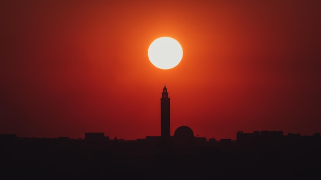 Silhouette mosque against orange sky