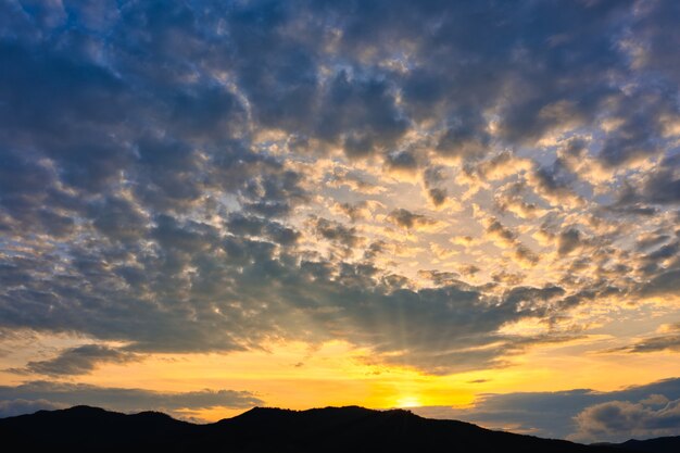 Silhouette of mountains with beautiful sunset with the bright setting sun