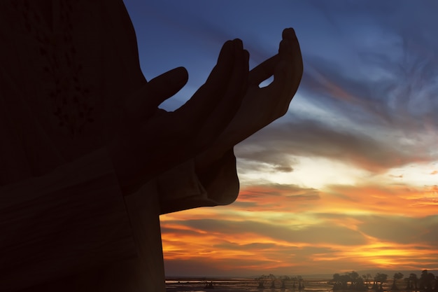 Silhouette of muslim man praying to god