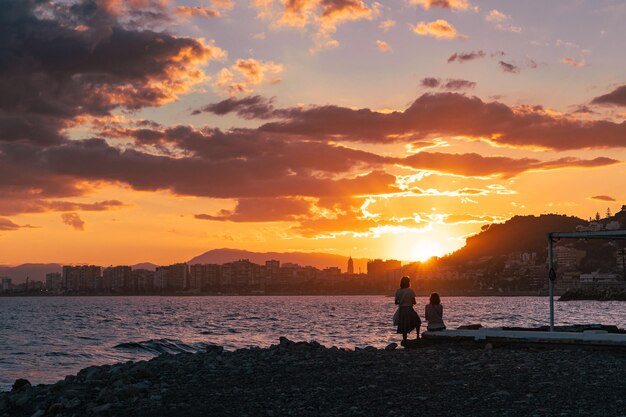 写真 サンセット ビーチでのカップルのシルエット