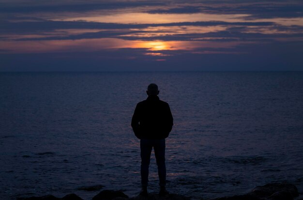 사진 해가 지는 동안 바다를 바라보는 성인 남자의 실루 알메리아 스페인