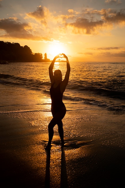 Фото Силуэт женщины, позирующей на пляже