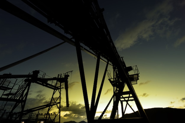 Silhouette of old conveyor belt at sunset