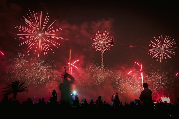 Silhouette people against firework at night