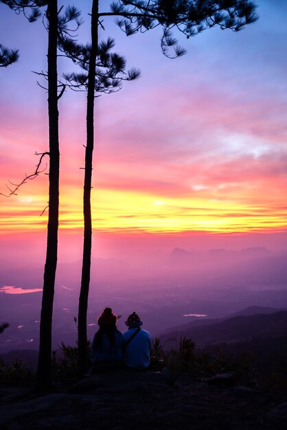 Фото Силуэт людей на оранжевом небе во время захода солнца
