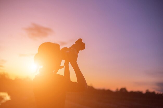 Silhouette people against orange sky during sunset