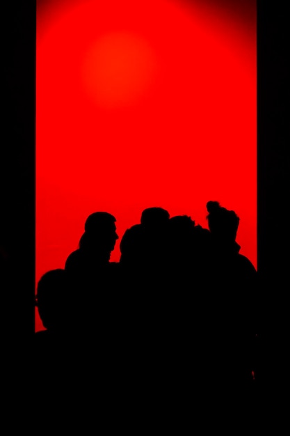 Silhouette people against red sky
