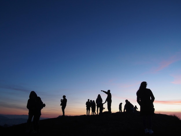 Silhouette people against sky during sunset