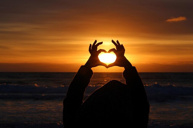 Silhouette of people at beach during sunset