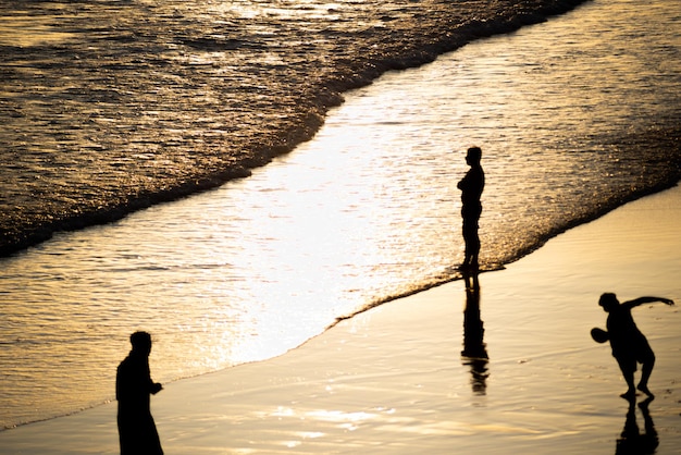 Photo silhouette people on beach