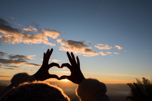 写真 夕暮れの空に照らされた木のシルエットの人々