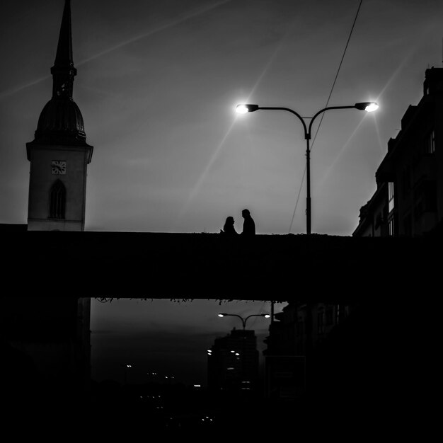 Photo silhouette of people in city at sunset