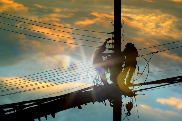 Silhouette people electrician working high on sky.