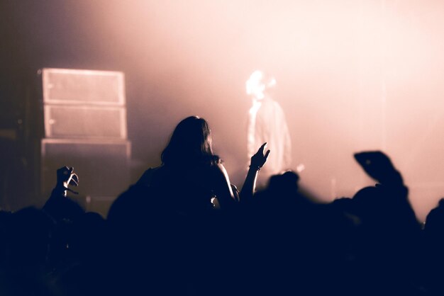 Photo silhouette people enjoying at music concert