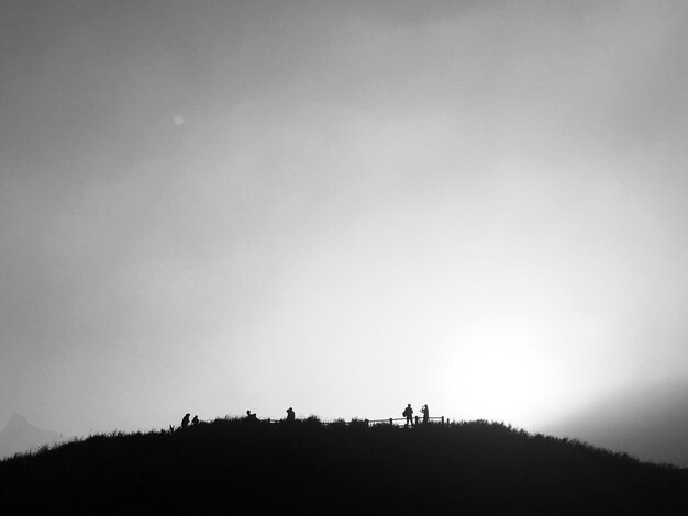 Silhouette people on field against clear sky