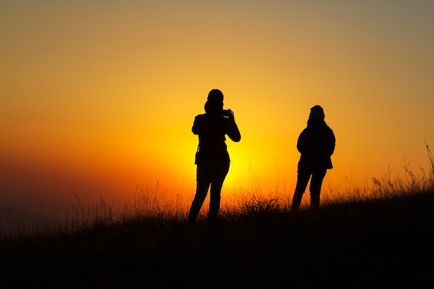 Photo silhouette of people having fun at sunset time