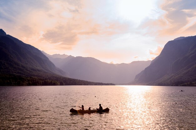 Foto silhouette di persone sul lago contro il cielo durante il tramonto