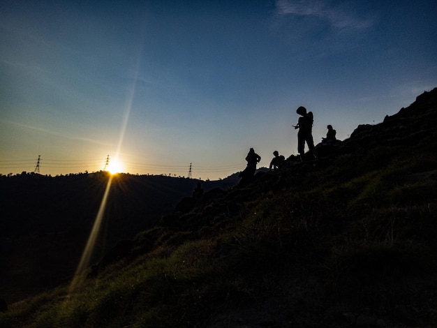 Foto silhouette di persone sulla terra contro il cielo durante il tramonto